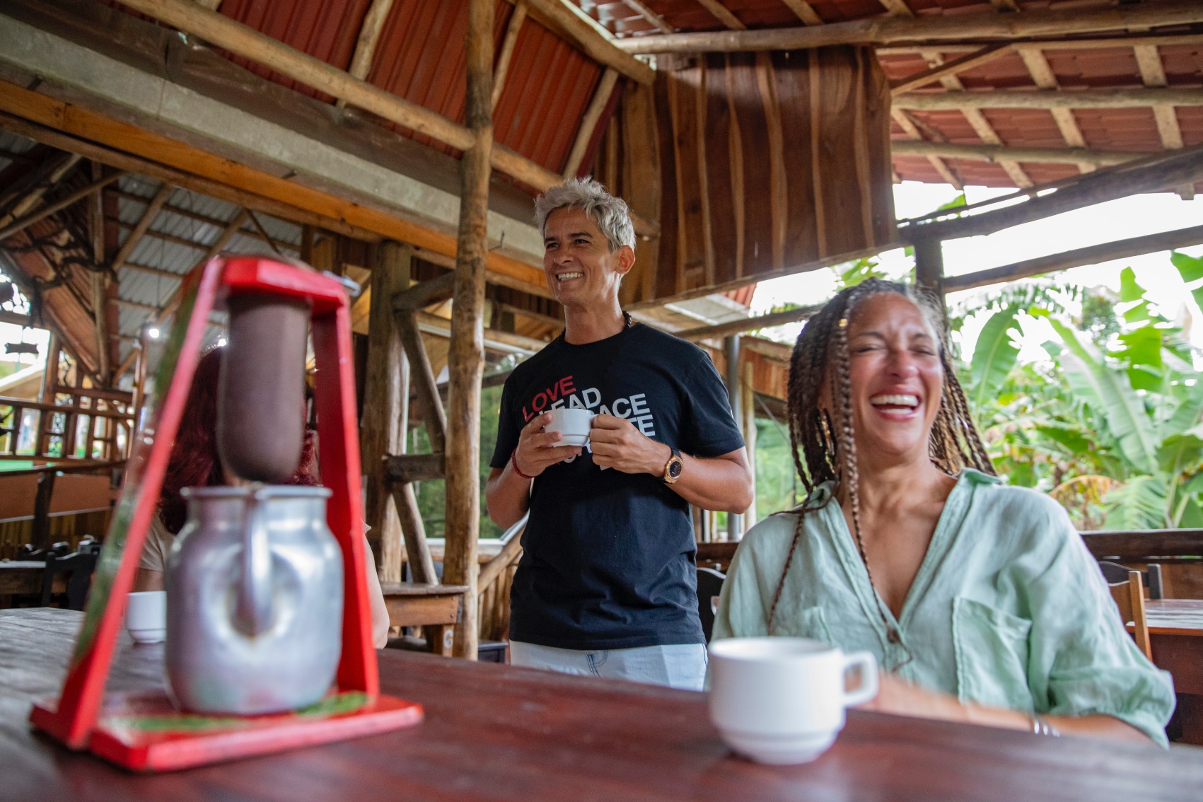 laughing over coffee a solo female traveller laughs along with her local guide at a coffee farm
