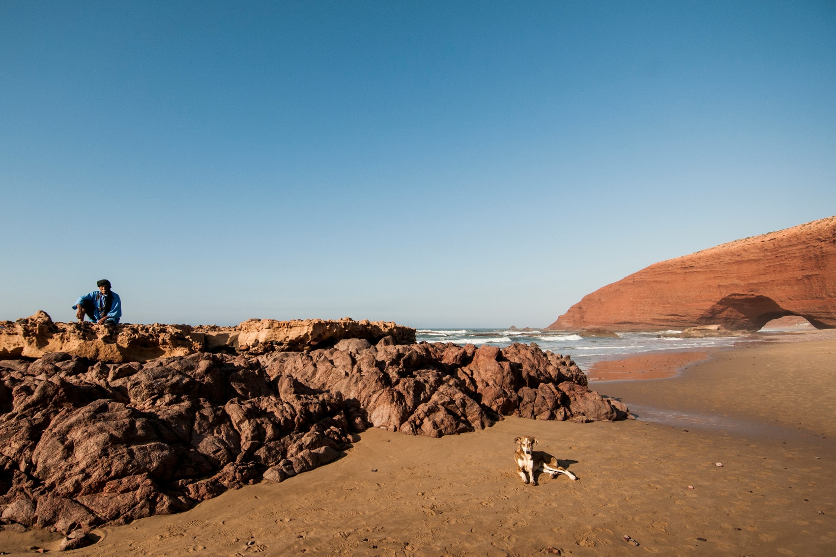 Legzira Beach Majestic arch of Legzira Beach with local person and dog